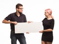 Young playful couple showing presentation pointing placard