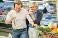 Ouple having fun while choosing fish in the supermarket. Royalty Free Stock Photo