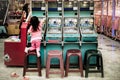 Young playfulgirl climbs on top of a chair trying to reach the top of the pinball arcade machine