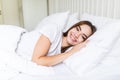 Young pleased sleeping on the side young woman smiling softly in bed Royalty Free Stock Photo