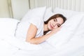 Young pleased sleeping on the side young woman smiling softly in bed Royalty Free Stock Photo