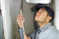 Young plumber fitting flexible pipe under kitchen sink Royalty Free Stock Photo