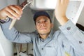 Young plumber fixing sink