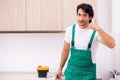 The young plumber repairing tap at kitchen Royalty Free Stock Photo