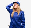 Young woman with plumber clothes isolated over grey background
