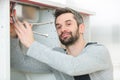 Young plumber working with pipe wrench in kitchen Royalty Free Stock Photo