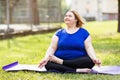 Young plump blonde girl meditates on a rug on a sunny evening. Healthy lifestyle concept