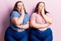 Young plus size twins wearing casual clothes bored yawning tired covering mouth with hand