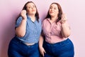 Young plus size twins wearing casual clothes doing italian gesture with hand and fingers confident expression