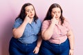 Young plus size twins wearing casual clothes pointing to the eye watching you gesture, suspicious expression Royalty Free Stock Photo