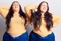 Young plus size twins wearing casual clothes suffering of neck ache injury, touching neck with hand, muscular pain Royalty Free Stock Photo