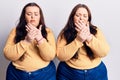 Young plus size twins wearing casual clothes suffering pain on hands and fingers, arthritis inflammation Royalty Free Stock Photo