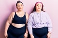 Young plus size twins wearing sportswear relaxed with serious expression on face