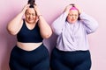 Young plus size twins wearing sportswear suffering from headache desperate and stressed because pain and migraine Royalty Free Stock Photo