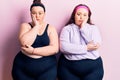 Young plus size twins wearing sportswear thinking looking tired and bored with depression problems with crossed arms