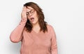 Young plus size woman wearing casual clothes and glasses yawning tired covering half face, eye and mouth with hand Royalty Free Stock Photo