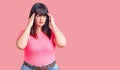 Young plus size woman wearing casual clothes with hand on head for pain in head because stress