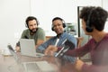 Young podcaster interviewing male entrepreneurs while recording podcast in office, copy space