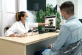 A young podiatrist wearing a mask explains the diagnosis to a young patient in her office Royalty Free Stock Photo