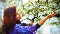 Young poetic woman with magnolia tree in the spring time. Woman holding flower.