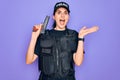 Young police woman wearing security bulletproof vest uniform and holding gun very happy and excited, winner expression celebrating Royalty Free Stock Photo