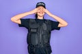 Young police woman wearing security bulletproof vest uniform over purple background covering eyes with hands smiling cheerful and Royalty Free Stock Photo