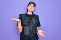 Young police woman wearing security bulletproof vest uniform over purple background smiling cheerful with open arms as friendly Royalty Free Stock Photo