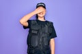 Young police woman wearing security bulletproof vest uniform over purple background smiling and laughing with hand on face Royalty Free Stock Photo