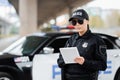 Young policewoman with tablet looking at