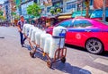 Young porter carying large packs of ice along the road at Pak Khlong Talat Flower Market in Bangkok, Thailand