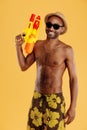 Young positive black man holding water gun Royalty Free Stock Photo