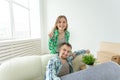Young funny positive couple holding keys to a new apartment while standing in their living room. Housewarming and family Royalty Free Stock Photo