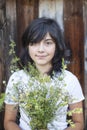 Young positive girl with a bouquet of wild flowers in the village. Nature. Royalty Free Stock Photo