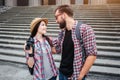 Young and positive man and woman stand in front of stairs and look at each other. They smile. People wear similar shirts Royalty Free Stock Photo