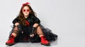 Young positive plus size girl model in bright rock style clothing, red boots and accessories sitting on floor