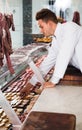 Young positive professional cook laying out food