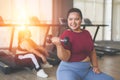 Young, Positive, Smiling, Cheerful overweight woman training with dumbbells in gym. Fat woman in sportswear doing fitness exercise Royalty Free Stock Photo