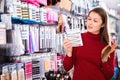 Young woman is choosing new hair clips in hair care store. Royalty Free Stock Photo