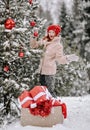 Young positive surprised woman in stylish clothing standing near decorated Christmas tree with heaps of present boxes Royalty Free Stock Photo