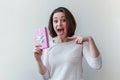 Young positive woman holding small pink gift box isolated on white background. Preparation for holiday. Girl looking Royalty Free Stock Photo