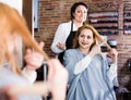 Woman points to master in hairdress salon right hair length for haircut
