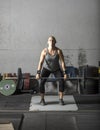 Young powerful woman lifting heavy weights in gym