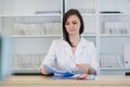 Young practitioner doctor working at the clinic reception desk, she is answering phone calls and scheduling appointments Royalty Free Stock Photo