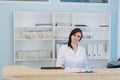 Young practitioner doctor working at the clinic reception desk, she is answering phone calls and scheduling appointments Royalty Free Stock Photo