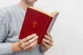 Young praying christian woman`s hands holding holy bible with a cross on a cover Royalty Free Stock Photo