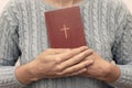Young praying christian woman`s hands holding holy bible with a cross on a cover Royalty Free Stock Photo