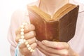 Young praying christian woman`s hands with a rosary and holy bible Royalty Free Stock Photo