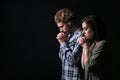 Young praying couple on dark background