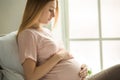 Young preganant woman expecting a baby relaxing on bed indoors Royalty Free Stock Photo