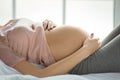 Young preganant woman expecting a baby relaxing on bed indoors Royalty Free Stock Photo